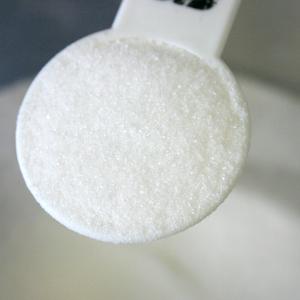 Photo of a measuring spoon filled with sugar
