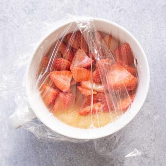Berries and applesauce in a bowl covered with wrap