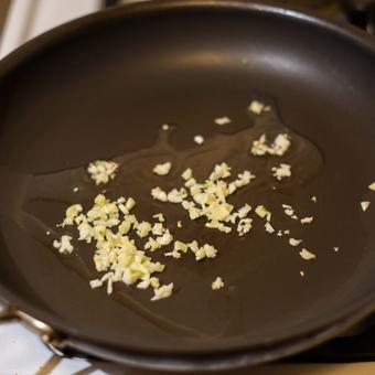 Chopped garlic cooking in a pan with olive oil