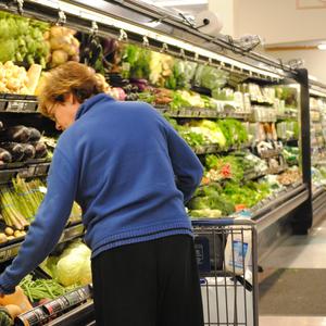 Photo of a woman shopping in the produce section of a grocery store