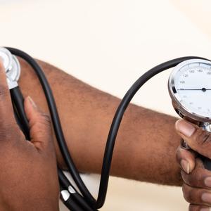 Photo showing one person checking another person's blood pressure