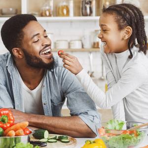 Photo of a girl and her dad preparing a salad