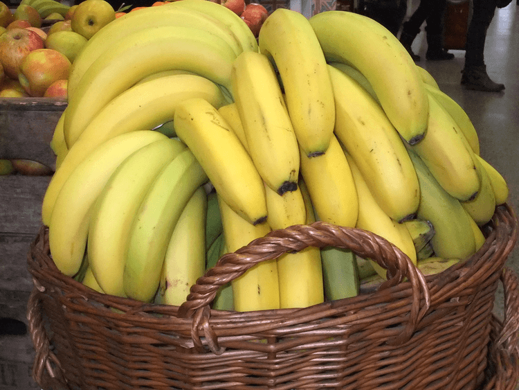 Photo of several bunches of ripe bananas in a basket