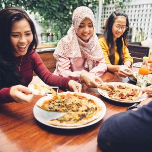Photo of a group of friends sharing pizza at a restaurant