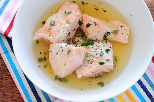 Photo of cooked salmon in a broth, in a bowl