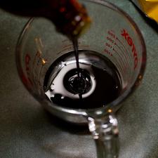 Photo of molasses being poured into a glass measuring cup