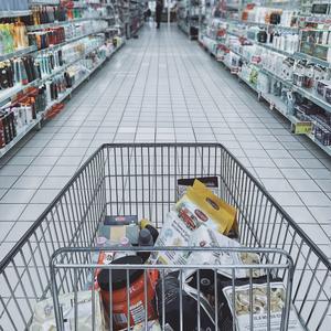 Photo of a Person Pushing a Nearly Full Grocery Cart