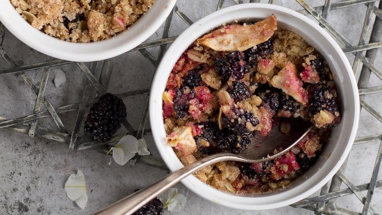 Photo of a berry crisp in a ramekin with a spoon